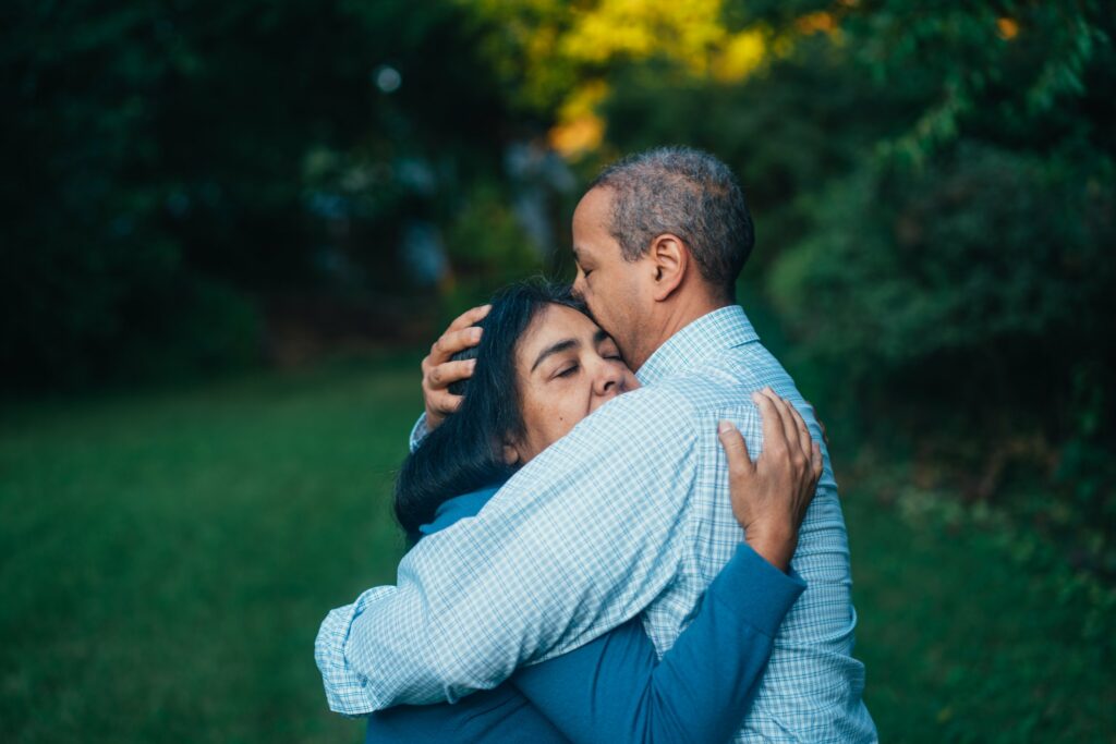 hispanic couple embracing outside
